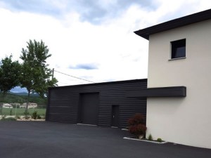 Vue sur la cour goudronnée, bureaux et atelier de stockage à Eurre construit pour des professionnels par BELCASTRO.