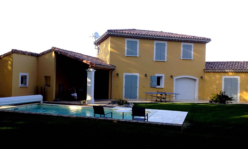 Construction maison facade jaune volets bleus piscine ouverte avec volet roulant à Montboucher sur Jabron par BELCASTRO.