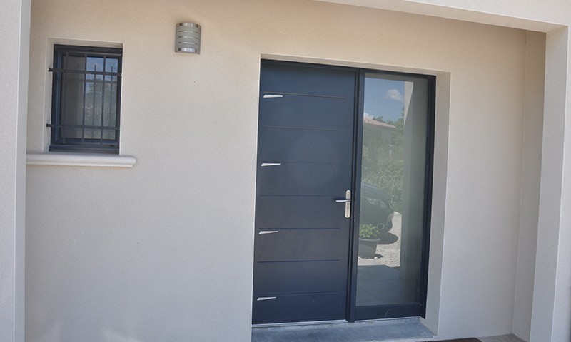 Construction d'une maison avec porte d'entrée alu et fenêtron barreaux à Eurre, par BELCASTRO Construction.