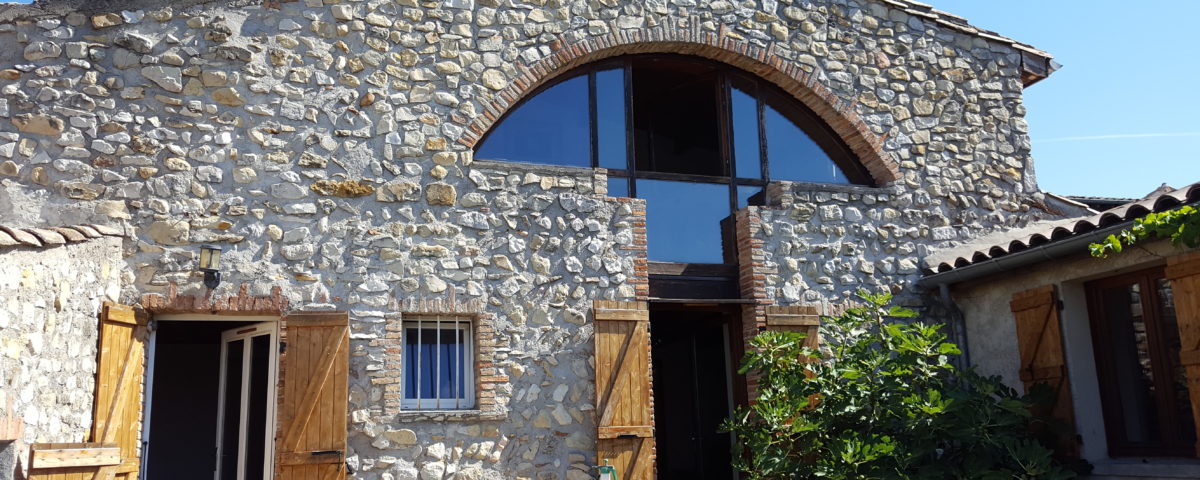 Défi réussi par BELCASTRO pour la rénovation de cette maison de village, façade pierre, fenêtre atypique arrondie.