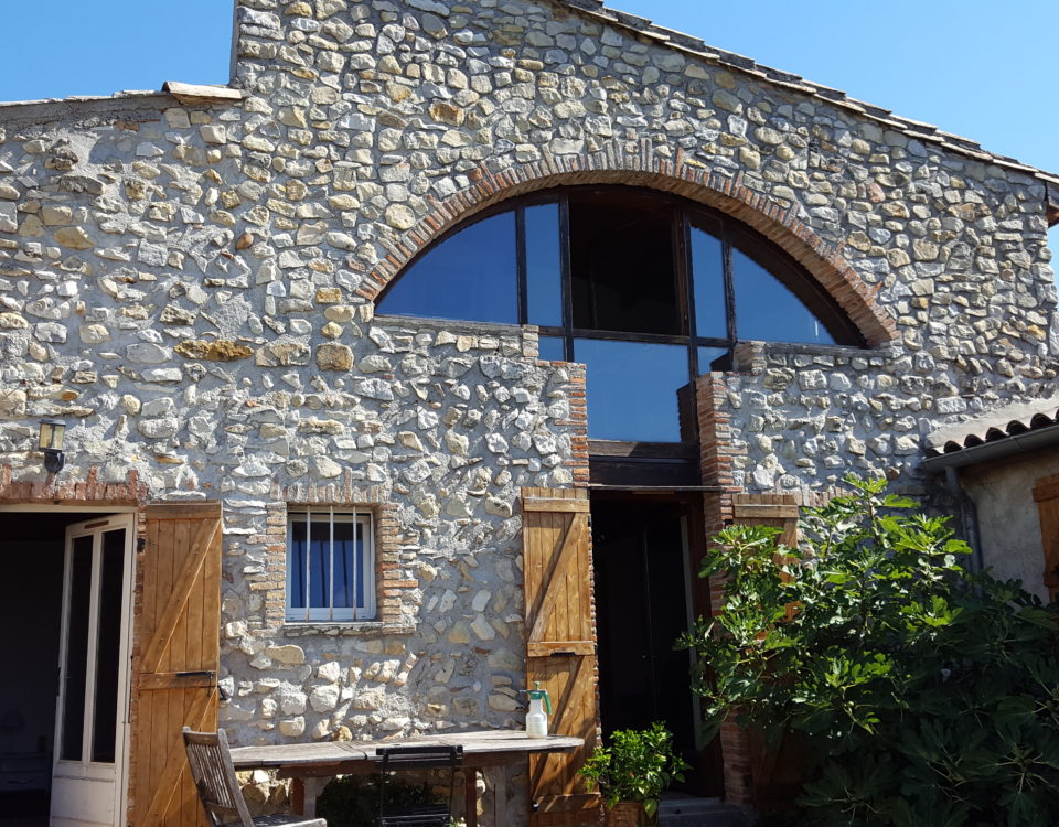 Défi réussi par BELCASTRO pour la rénovation de cette maison de village, façade pierre, fenêtre atypique arrondie.