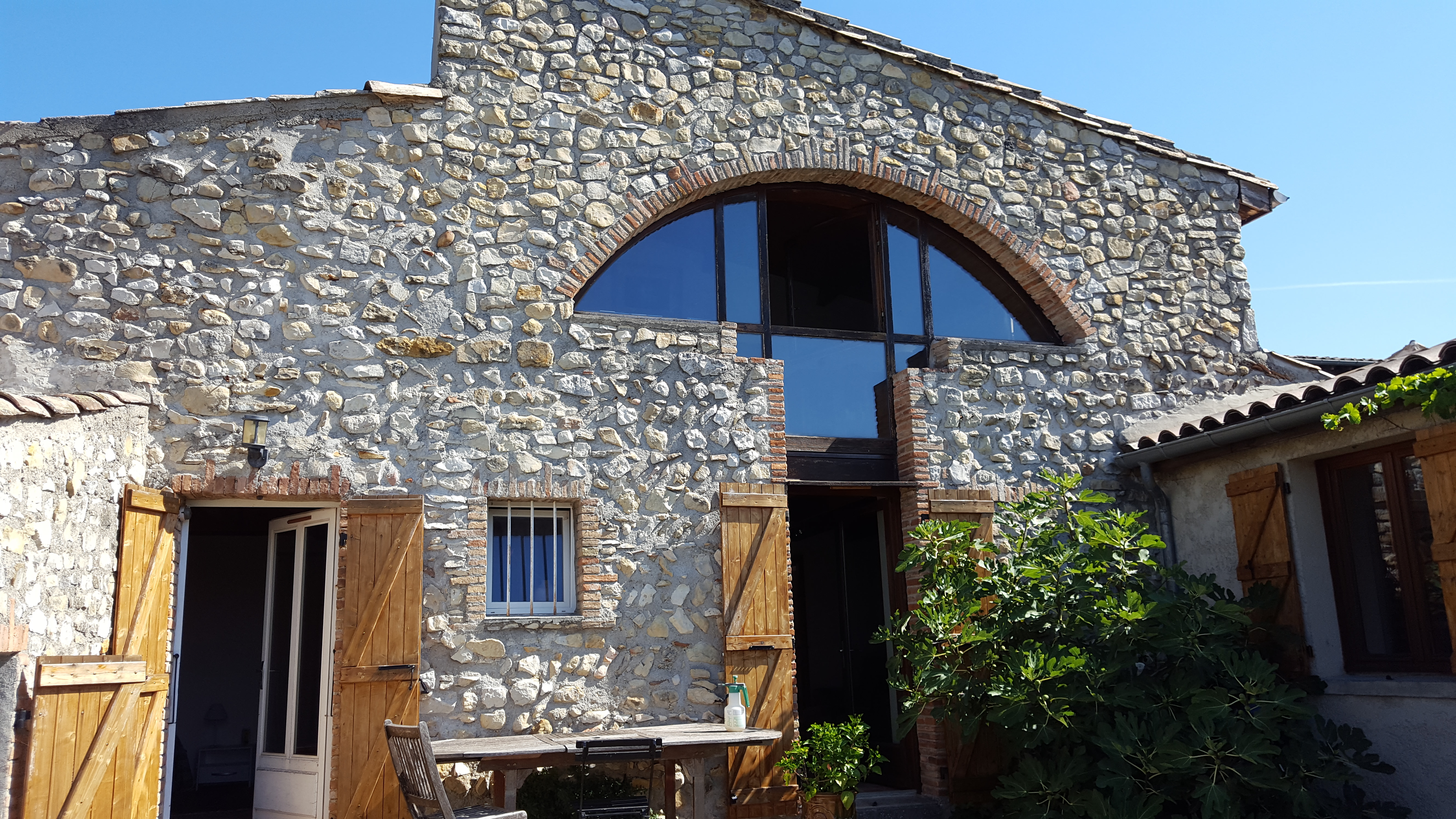 Défi réussi par BELCASTRO pour la rénovation de cette maison de village, façade pierre, fenêtre atypique arrondie.