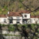 Vue sur la façade blanche d'une villa à travers la végétation, une réalisation BELCASTRO.