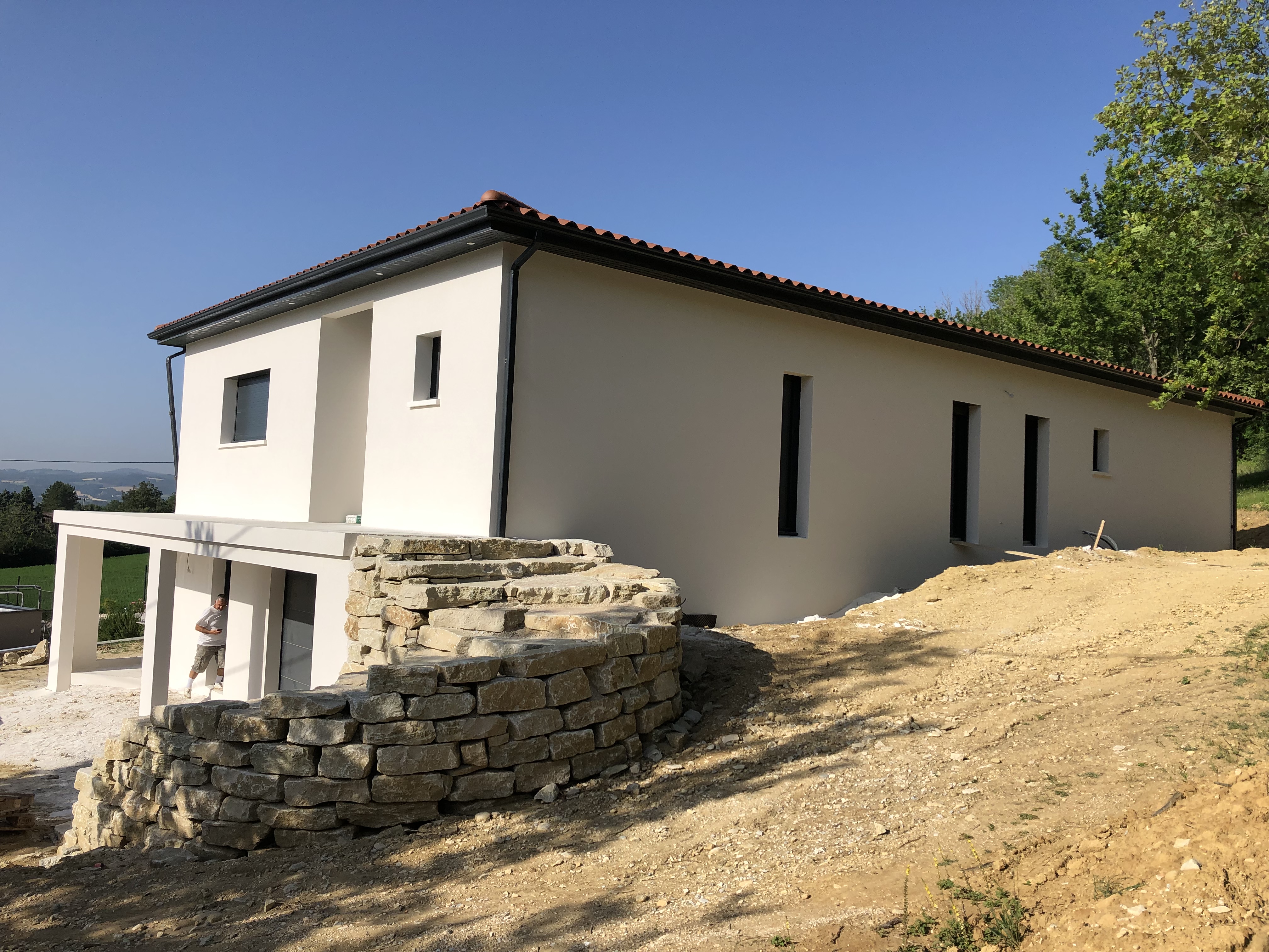Construction d'une maison toute neuve avec façade blanche et toiture grise, porche terrasse par BELCASTRO.